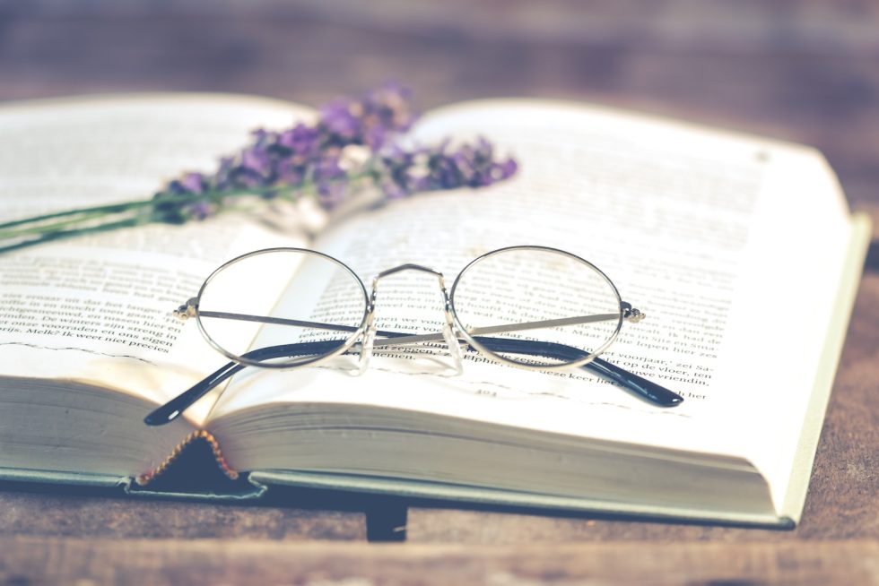 Silver-colored Framed Eyeglasses on Open Book